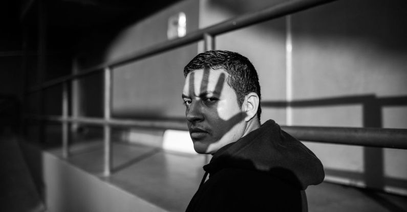 Stigma - Monochrome Photo of Man Wearing Hoodie